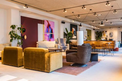 a room with couches and chairs and a table at Le Grand Quartier in Paris