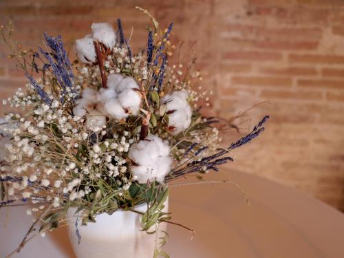 a white vase with a bouquet of flowers at Luxury Apartment Stancesvic in Vic