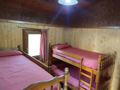 two bunk beds in a room with a window at Camping Casa Fausto Cerca de Dinopolis in Formiche Alto