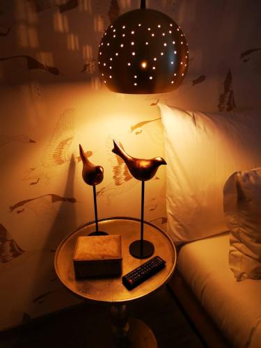 a table with two birds on it next to a bed at Casa do Castelo in Sernancelhe