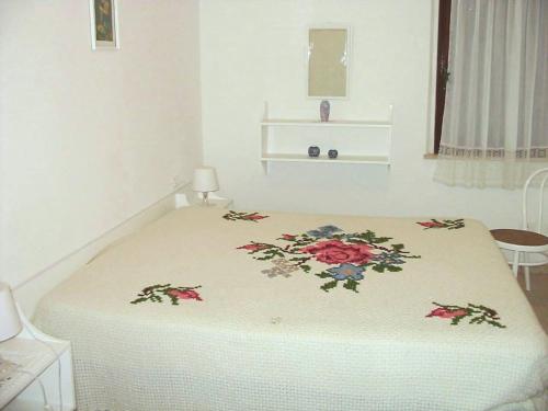 un dormitorio con una cama con un estampado de flores. en Casa Grazia a soli 100m dal mare Marina di Castagneto, en Marina di Castagneto Carducci
