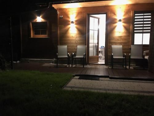 a group of chairs sitting on a porch at night at Apartament Centrum Zakopane in Zakopane