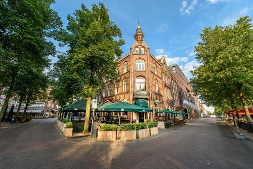 un gran edificio de ladrillo con una torre de reloj en una calle en BnB prins Hendrik Venlo, en Venlo