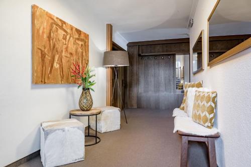 a living room with two chairs and a vase of flowers at Bed & Breakfast Fender in Sölden