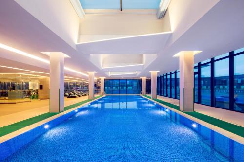 a large swimming pool in a building with windows at Holiday Inn Wuxi Taihu New City by IHG in Wuxi