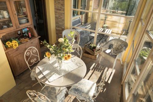 a table and chairs with a vase of flowers on it at Alpaca country house in Pontedera