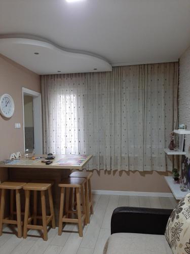 a living room with a table and chairs and a window at Apartman Ana in Šabac