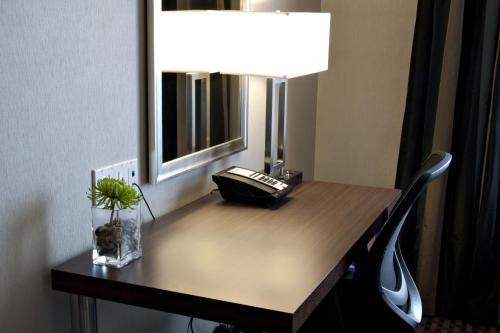 a desk with a telephone and a lamp on it at Holiday Inn Express Pembroke by IHG in Pembroke