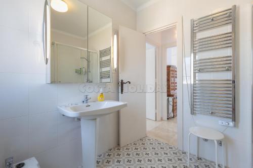 La salle de bains blanche est pourvue d'un lavabo et d'un miroir. dans l'établissement Los Reales 8C, à Estepona