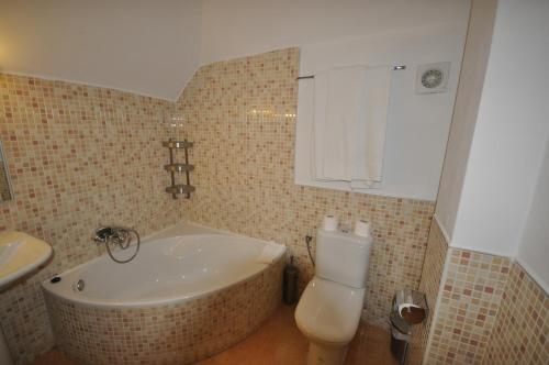 y baño con bañera, aseo y lavamanos. en Apartamentos Sabica, en Sierra Nevada