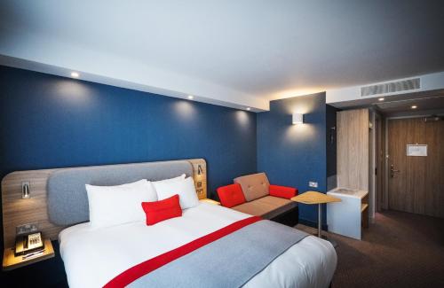 a hotel room with a large bed and a couch at Holiday Inn Express - Stockport by IHG in Stockport