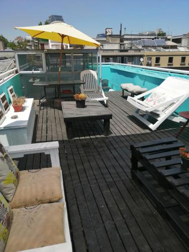 a deck with chairs and a table and an umbrella at Bella 269 Guest house in Santiago