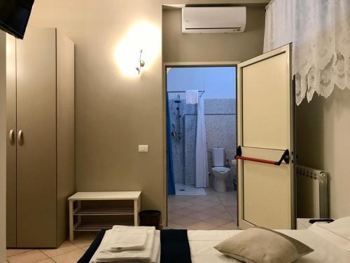 a bedroom with a bed and a door to a bathroom at B&B Luminari in Rome