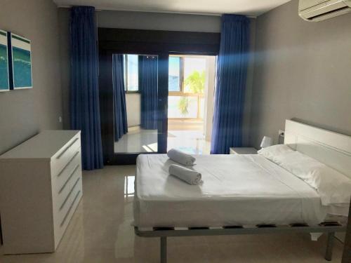 a bedroom with a bed and a large window at Seafront Levante Beach Blueline in Benidorm