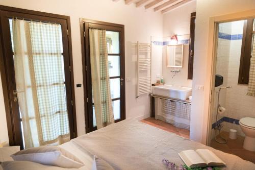 a bedroom with a bed and a bathroom with a sink at Alpaca country house in Pontedera
