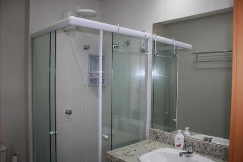 y baño con ducha acristalada y lavamanos. en Tavarua Itacimirim Hirata, en Camaçari