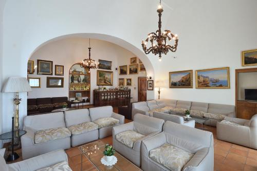 a living room with white couches and a chandelier at Hotel Luna Convento in Amalfi
