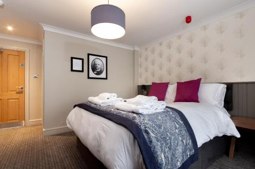 a bedroom with a bed with towels on it at The Eaton Oak in Saint Neots