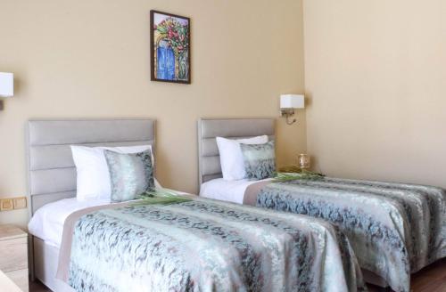 a bedroom with two beds and a lamp at Golden Palms Guest House & Cafe in Famagusta