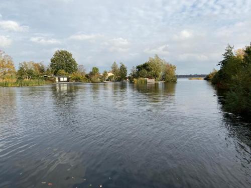 a large body of water with trees on the side at C'est la Vie Houseboat in Nederhorst den Berg