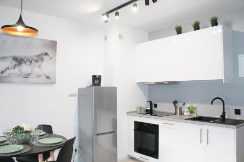 a kitchen with a table and a refrigerator at Apartamenty Ski & Fun Spokojna in Wisła