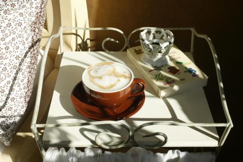a cup of coffee on a white table with aucer at Landhotel Pension Haus Sonneck in Manderscheid