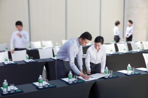 a man and woman looking at a piece of paper at Holiday Inn Wuxi Taihu New City by IHG in Wuxi