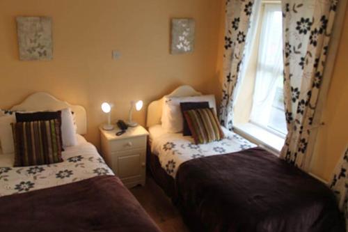 a small bedroom with two beds and a window at No 1 Leitrim Road in Carrick on Shannon