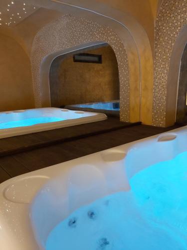 a bathroom with a bath tub with a sink at Alexakis Hotel & Spa in Loutra Ipatis