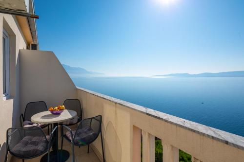 a balcony with a table and chairs overlooking the water at Apartments & Restaurant Galeb in Marusici 