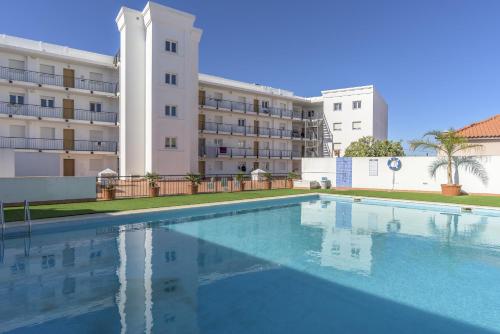 an empty swimming pool in front of a building at FLH Vila Real Santo António Flat with Pool in Vila Real de Santo António