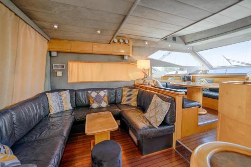 - un salon avec un canapé en cuir dans un bateau dans l'établissement HEBERGEMENTS BATEAUX A QUAI, à Porquerolles