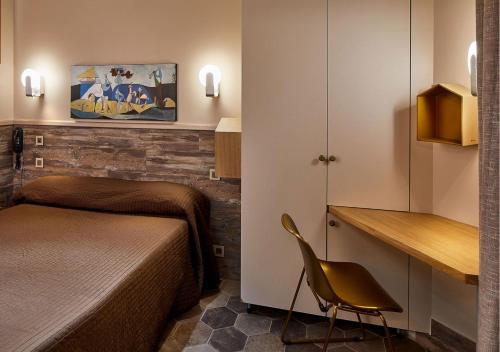 a bedroom with a bed and a desk and a chair at Hôtel de Roubaix in Paris