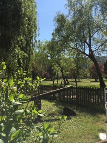 a fence in a park with trees and grass at Camping Playa Sauces in Ribadesella