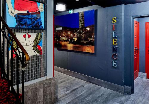 a wall with posters on it with a sign on it at Hôtel de Roubaix in Paris