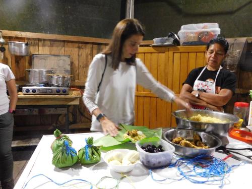 a woman standing in a kitchen preparing food at Intillama Jungle Lodge EIRL in Paucarpata