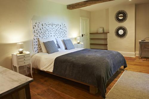 1 dormitorio con 1 cama grande con almohadas azules en Chambres d'hôtes du Domaine de Bonnery en Caucalières