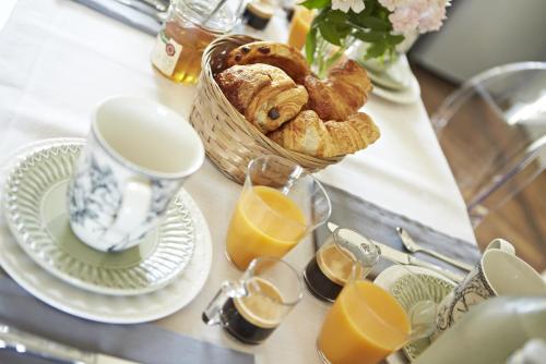 a table with a basket of bread and a basket of orange juice at Chambres d'hôtes du Domaine de Bonnery in Caucalières