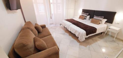 sala de estar con sofá y cama en Fan Rooms Duquesa, en Málaga