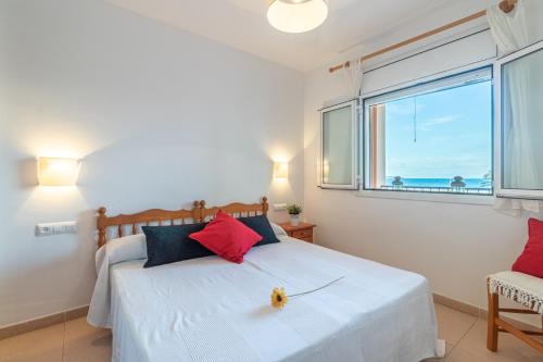 een slaapkamer met een bed en een groot raam bij Empurialola -Apartamento en primera linea de ma vistas al mar -164 in Empuriabrava