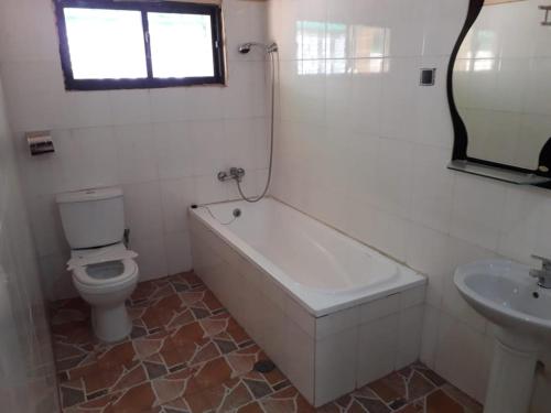 uma casa de banho com uma banheira, um WC e um lavatório. em Afilux Residencial em Luanda