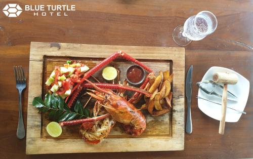 a plate of food with a lobster and french fries at Blue Turtle Hotel in Tissamaharama