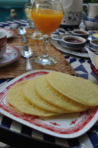 a table with a plate of bread and a glass of orange juice at Riad Abaka hotel & boutique in Marrakech