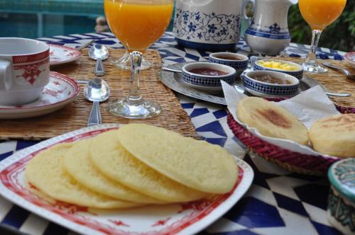 een tafel met borden brood en glazen sinaasappelsap bij Riad Abaka hotel & boutique in Marrakesh