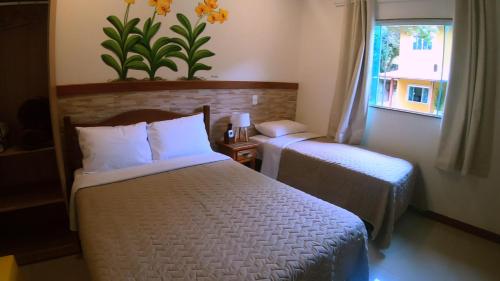 A bed or beds in a room at POUSADA DAS ORQUIDEAS20
