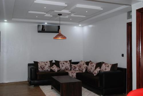 a living room with a black couch and a table at Elmoapart in Agadir