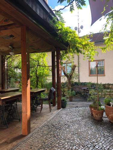 un patio esterno con tavoli, sedie e alberi di Family Lorenz & Coffee House a Praga