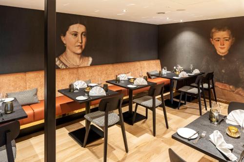 a restaurant with tables and chairs and a portrait of a man at WunnersWat Verl in Verl