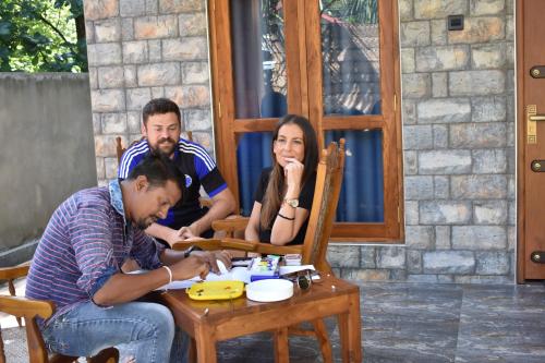 a group of people sitting at a table at Forest Edge Safari Villa in Udawalawe