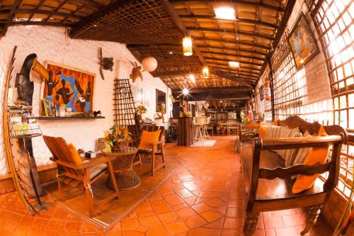 a room with chairs and tables in a building at Pousada Sonho da Lagoa in Praia do Forte